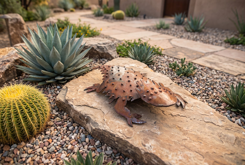 Rusted steel horned lizard sculpture viewed from a lower angle with a garden path leading to the home entrance