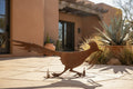 Rusted metal roadrunner sculpture, running pose