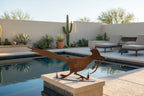 Rusted metal roadrunner sculpture, running pose