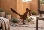 Rusted metal roadrunner sculpture, standing pose