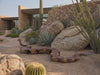 Rusted steel snake sculpture in a desert courtyard, homepage hero video