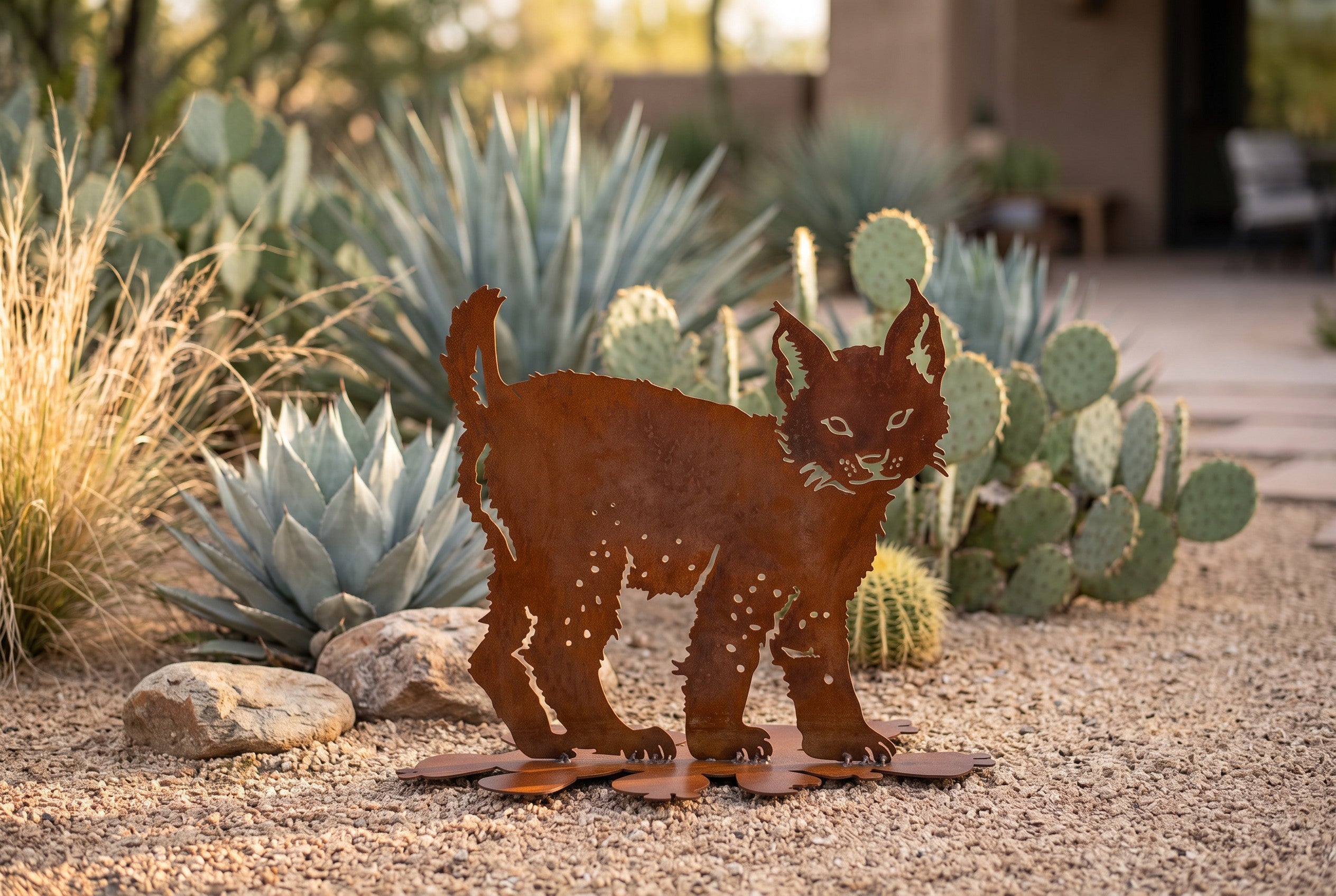 Freestanding Sculpture collection - rusted steel bobcat sculpture among agave and prickly pear in a desert courtyard